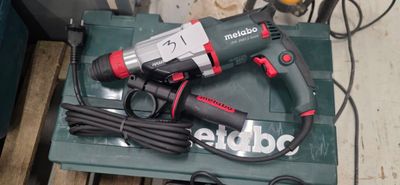 a corded drill sitting on top of a green box