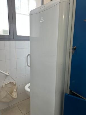 a white refrigerator in a bathroom next to a blue door