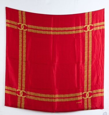une photo d'une nappe rouge et dorée accrochée à un mur