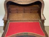 a wooden desk with a red cushion underneath it