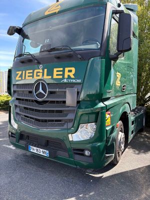 un camion vert garé sur le bord de la route