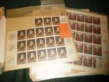 de nombreux timbres posés sur une table, sur lesquels figure l'image d'une femme