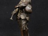 bronze figurine of a man with a gun and a hat
