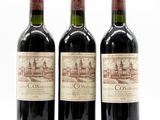 three bottles of red wine sitting next to each other on a white surface