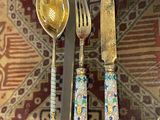 two forks and a spoon sitting on a table