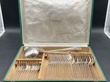 a green case with silverware in it on a table
