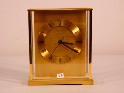 a gold clock with roman numerals on the face