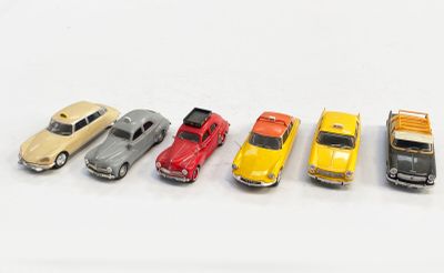 plusieurs petites voitures sont alignées sur une surface blanche