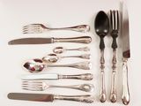 a lot of silverware on a table with a spoon and knife