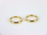 two gold wedding rings on a white background
