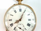 une montre de poche en or avec des chiffres romains sur le cadran