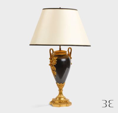 une lampe noire et dorée avec un abat-jour blanc