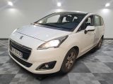 la petite voiture blanche est garée sur un carrelage à carreaux