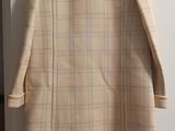 coat hanging on a hanger in a room with a door open