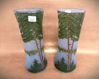 two vases with trees painted on them sitting on a table