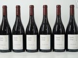 six bottles of wine are lined up in a row on a table