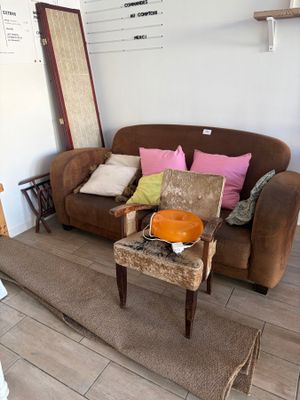 un salon avec un canapé marron et un fauteuil marron