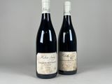deux bouteilles de vin rouge posées l'une à côté de l'autre sur une table