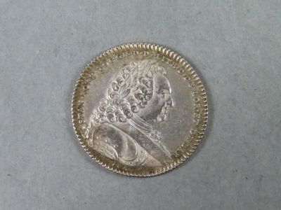 Gros plan sur une pièce d'argent portant le visage d'un homme