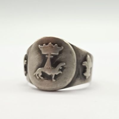 une image représentant une bague en argent ornée d'un cheval et d'une couronne