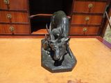 statue représentant un taureau et un veau, posée sur un socle dans une pièce