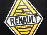 un vieux panneau jaune et noir sur lequel figure le mot « Renault »