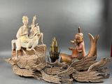 une statue représentant un homme et une femme assis sur une bûche