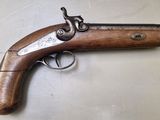 un gros plan d'un pistolet à crosse en bois posé sur une table