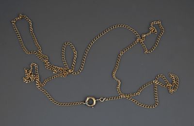 a close up of a gold chain with a clasp on a gray surface