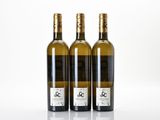 three bottles of white wine sitting next to each other on a table