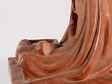 statue of a woman with a veil on her head sitting on a rock