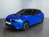 a blue car parked in a room with a white wall