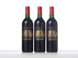 three bottles of red wine sitting on top of a table