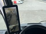 a tablet on the dashboard of a car with a view of a truck