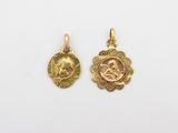 une paire de pendentifs en or représentant la tête d'un homme et d'une femme