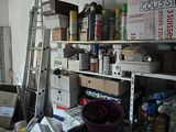 une pièce encombrée où se trouvent une échelle, des cartons et d'autres objets