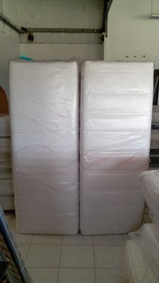 two mattresses that are stacked up in a room