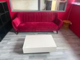 a red couch and a white coffee table in a living room