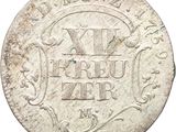 a close up of a silver coin with a design on it