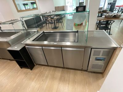 a stainless steel counter with a glass top and a sink