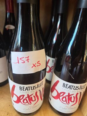 several bottles of wine on a shelf with a price tag on them