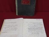 an open book sitting on top of a red cloth covered table