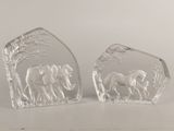 pair of clear glass elephant bookends on a white surface