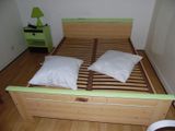 a wooden bed with two pillows on top of it