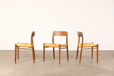 three wooden chairs with yellow upholstered seats in a room