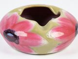 a vase with a flower design on it on a white surface