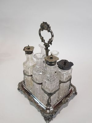 un plateau en argent sur lequel est posé un ensemble composé d'une bouteille en argent et d'un verre