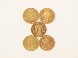 four gold coins are arranged in a pyramid on a white surface