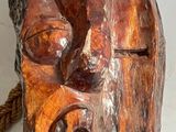a wooden sculpture of a face on a piece of wood