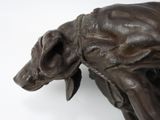 a statue of a dog that is standing on a white surface